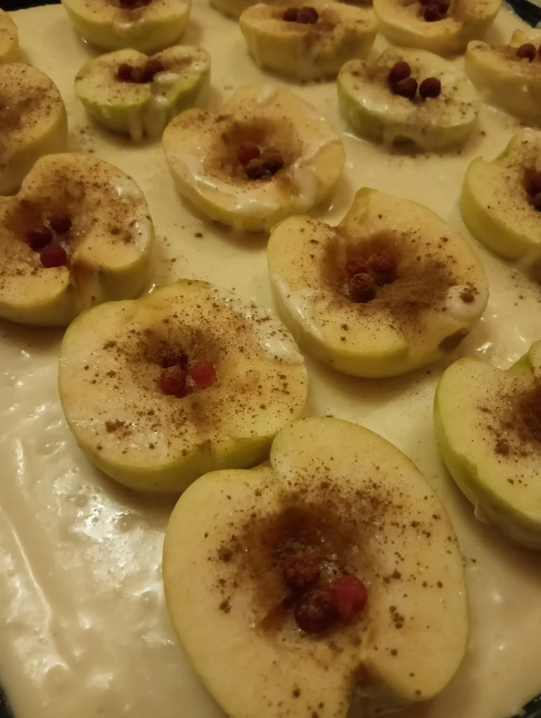 Sliced apples with cinnamon and berries in the center, prepared for baking.